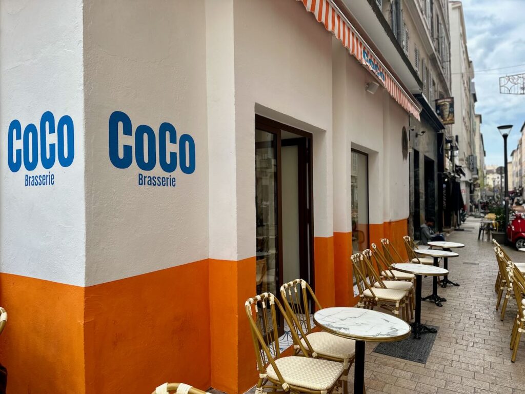 Coco est une brasserie située sur la place de l’opéra municipale. Elle dispose d’une belle terrasse ensoleillée. (enseigne)