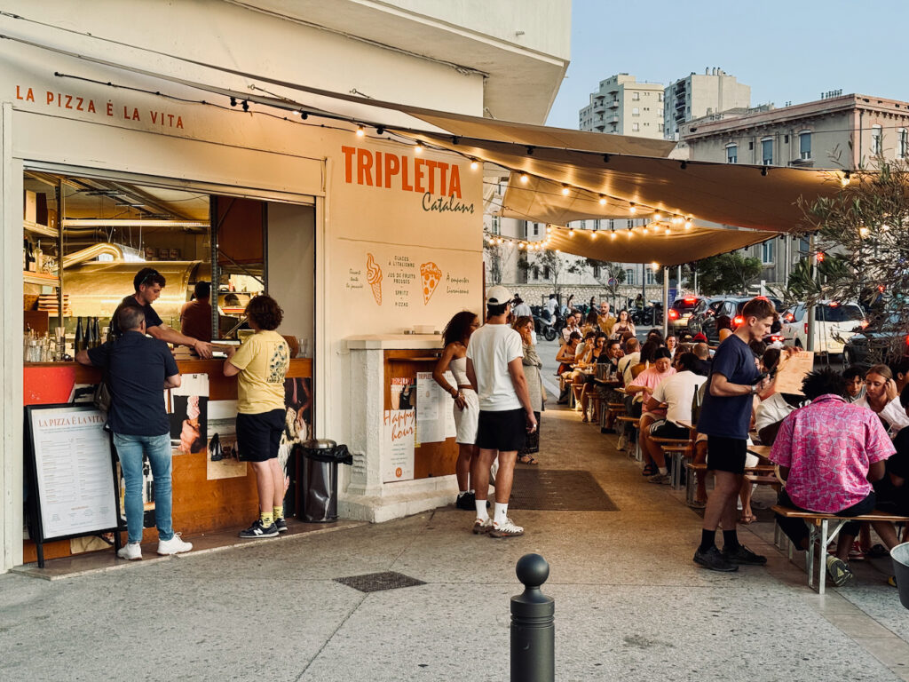 Tripletta Catalans est une pizzeria et un bar situé en face de la plage des Catalans à Marseille. L’adresse propose, vue mer, des pizzas, des cocktails et d’autres antipastis et desserts italiens. (corner)
