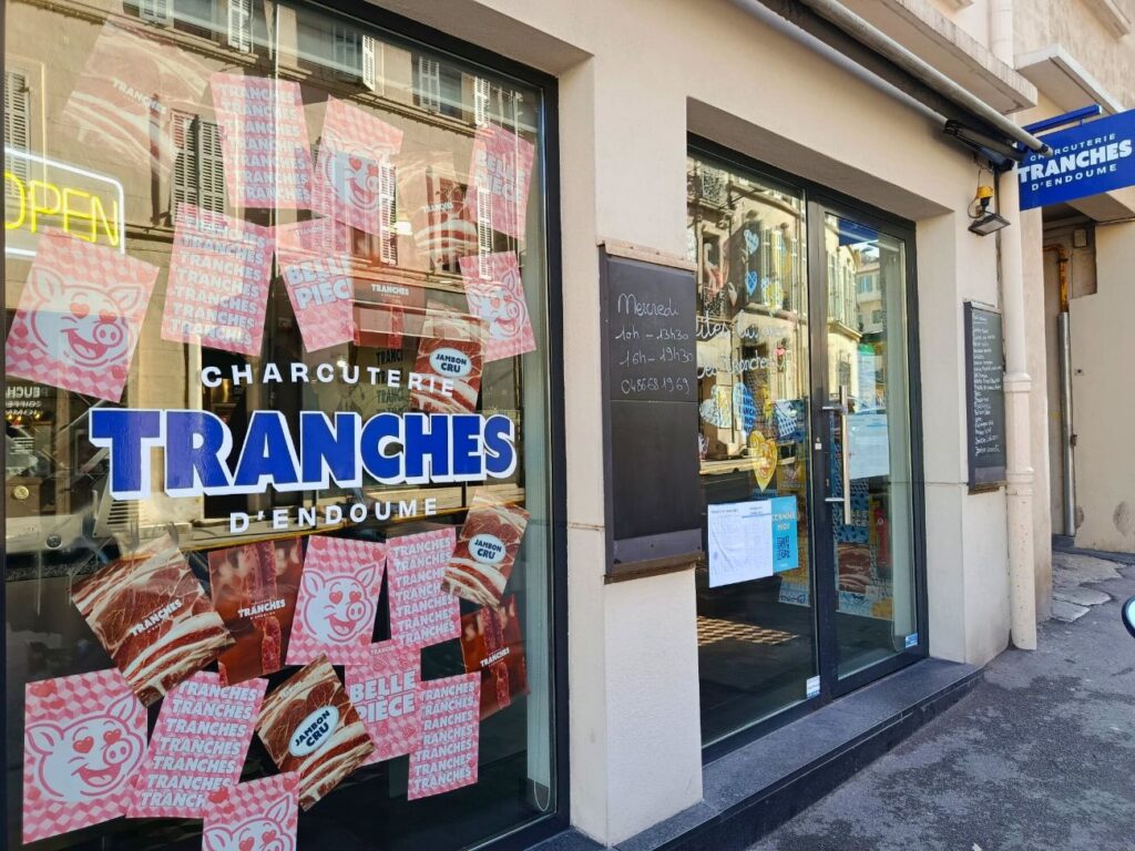 Tranches est une charcuterie artisanale située dans le quartier d'Endoume. Un lieu accueillant, tenu par Caroline et Anthony, qui cultive l'art du bon produit (vitrine large)
